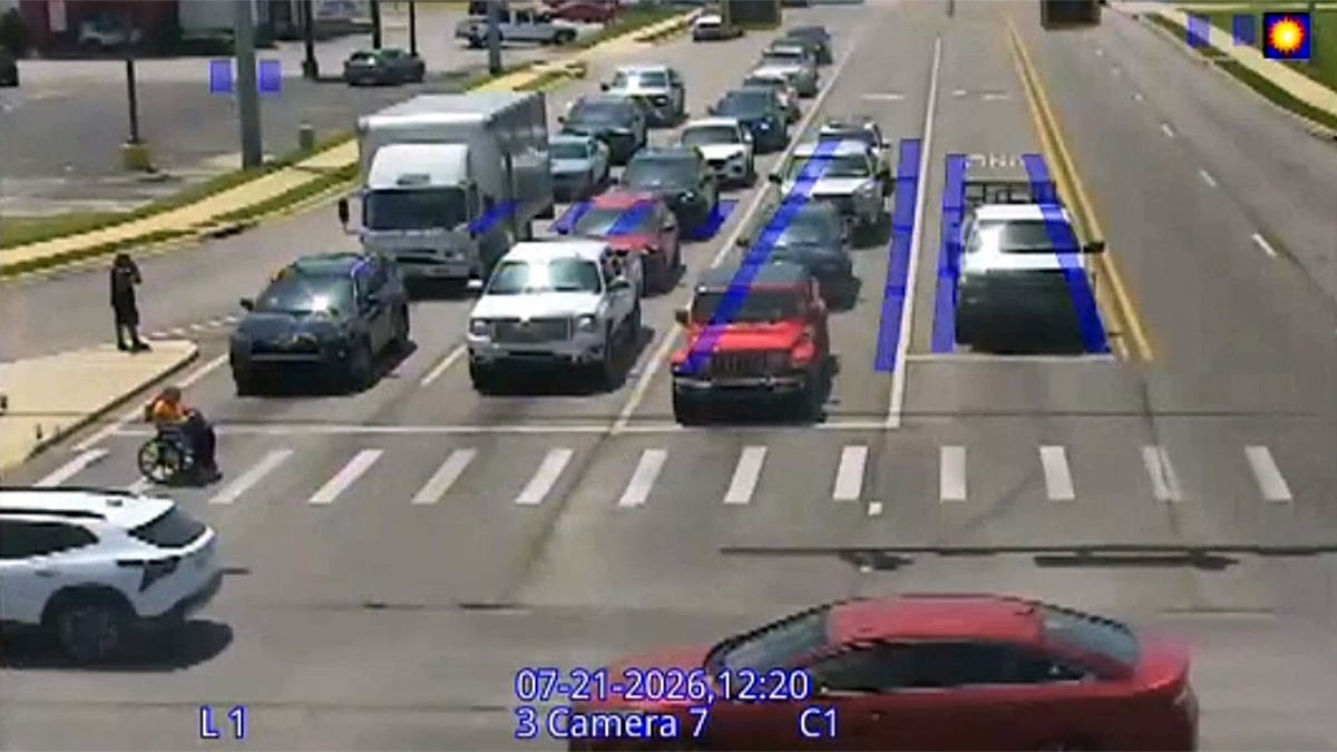 Person in wheelchair helped across Arkansas intersection by driver wearing a Spider-Man costume