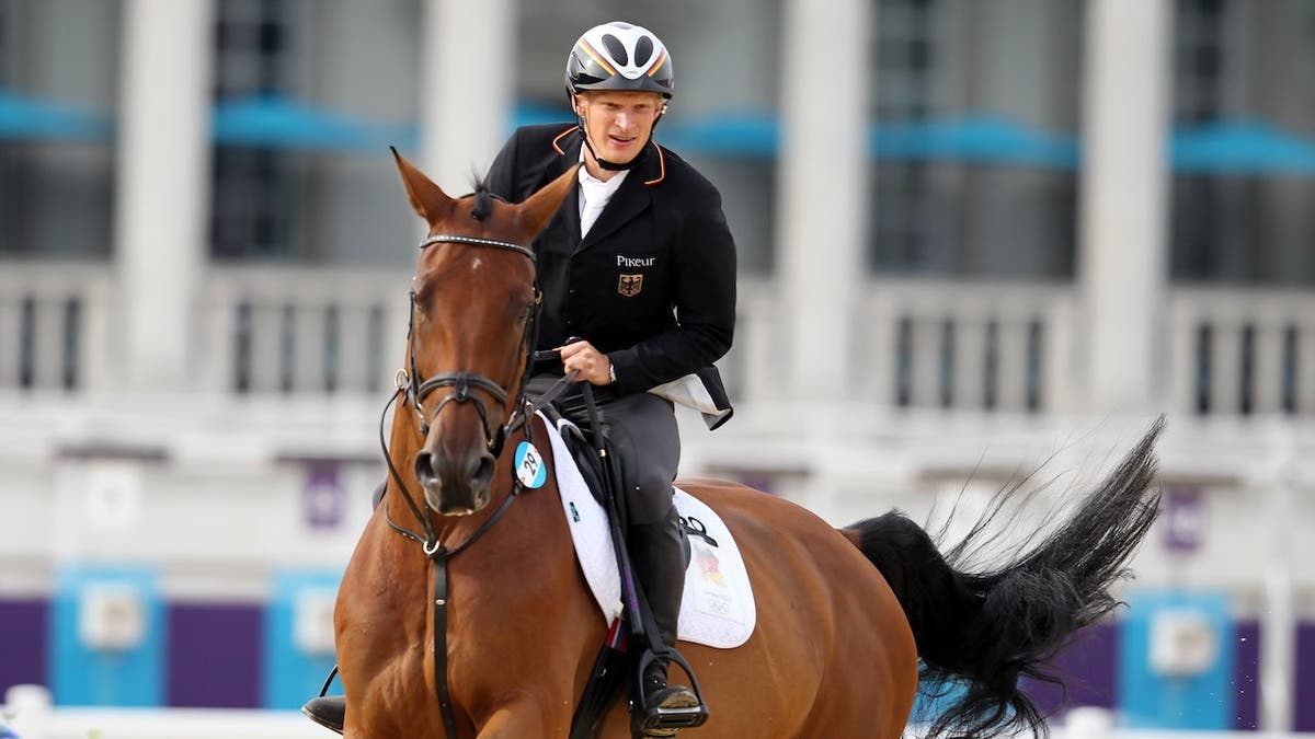 Steffen Gebhardt rides a horse over a jump at the Olympic Summer Games in London.