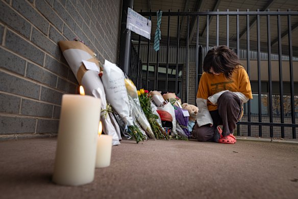One of Fitzgerald’s students, Macey Moderana, lays flowers at the school where he taught.
