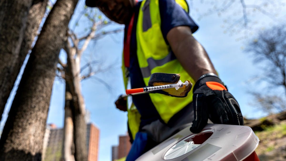 Danilo participates in a needle clean-up in a Bronx park.