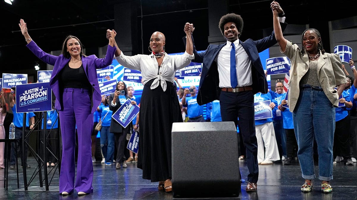 Justin J. Pearson stands onstage with Alexandria Ocasio-Cortez, Ayanna Pressley and Summer Lee at a campaign rally.