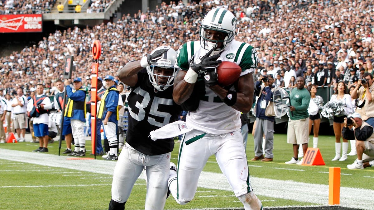 Plaxico Burress scores a touchdown against Chimdi Chekwa during an NFL game.