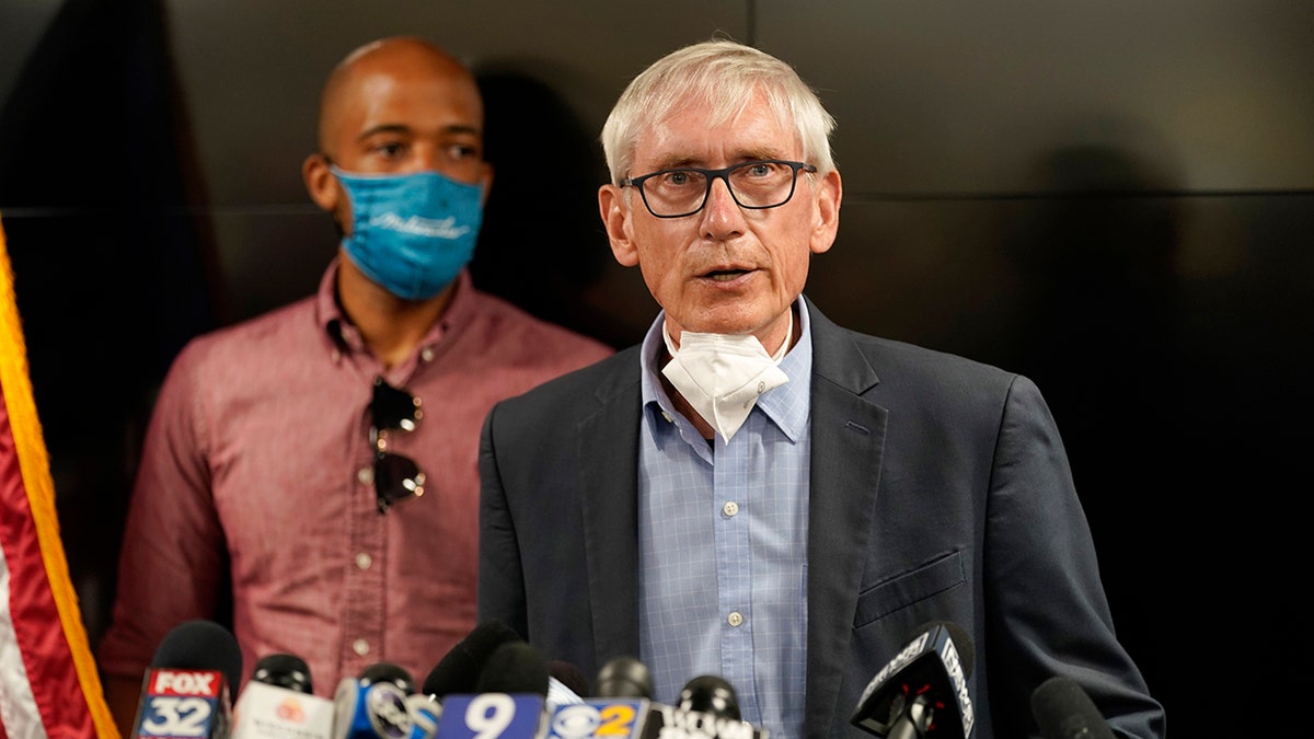 Wisconsin Governor Tony Evers speaks during a news conference Thursday, Aug. 27, 2020, in Kenosha, Wis. The city has suffered from unrest in the wake of the police shooting of Jacob Blake. Lt. Gov. Mandela Barnes is at rear. (AP Photo/Morry Gash)