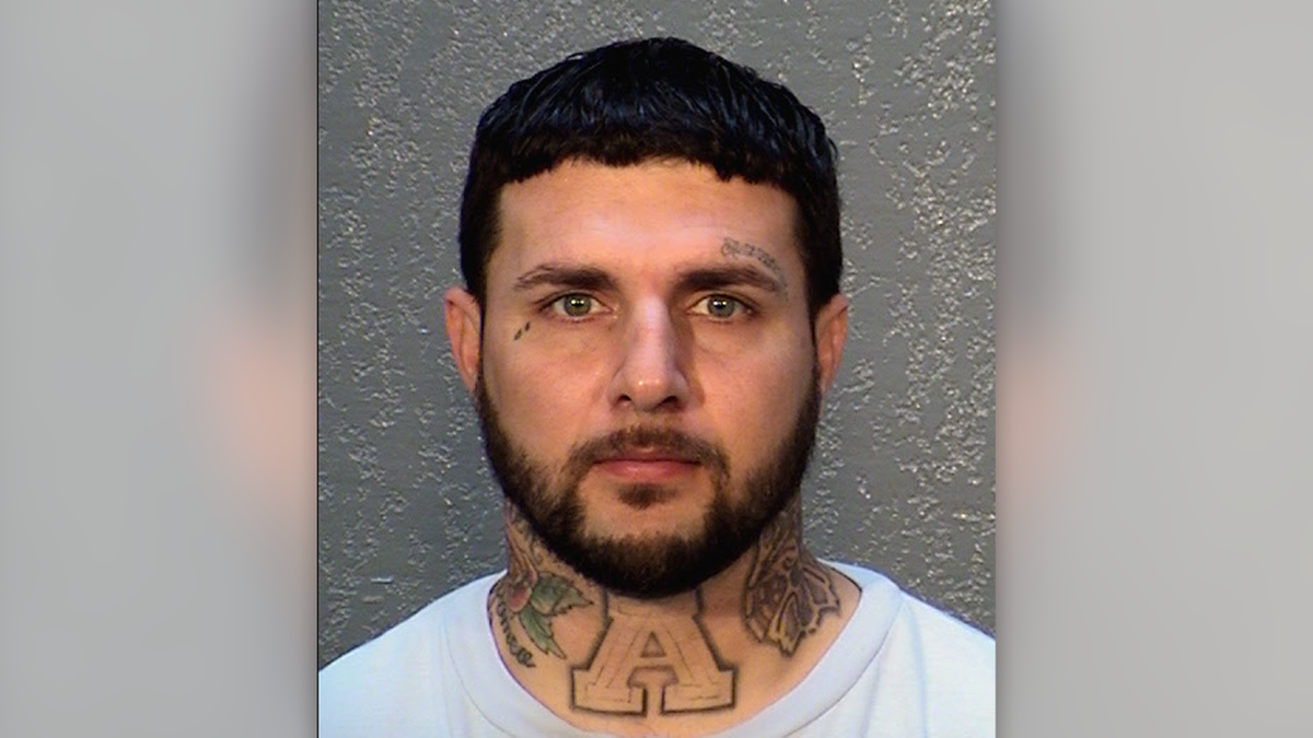 Santiago Rogers has neck and face tattoos and a short-cropped beard in his mugshot