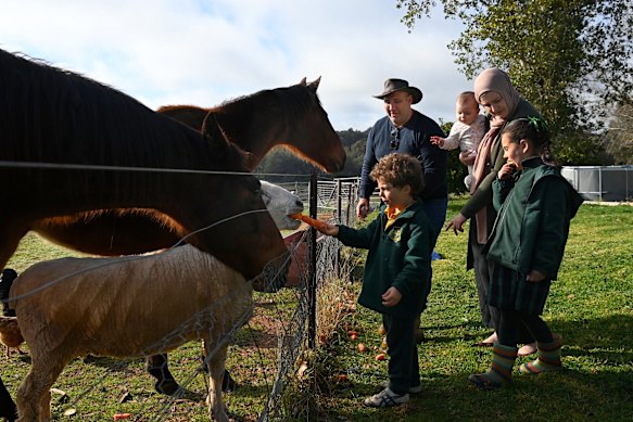 Omar Kowaider and his wife Joanne feed the family pets with their children Hakeem (front left), Hannah and Leila (right) on their property in Young.