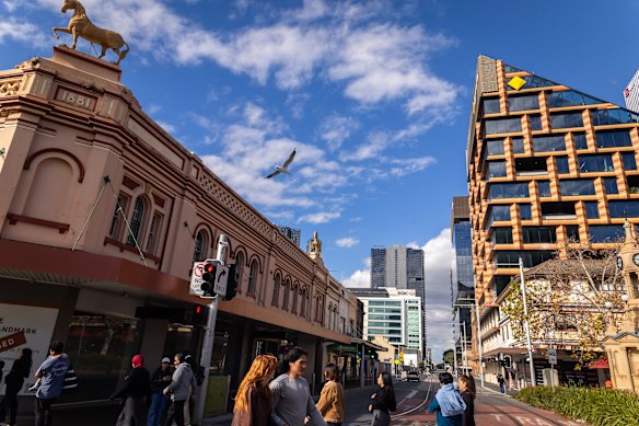 People crossing the light rail tracks at the corner of Church and Macquarie Streets. 