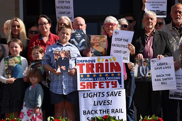 Families and friends who have lost loved ones at passive rail crossings gather at Parliament House.