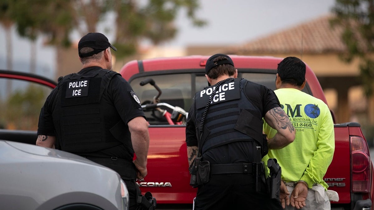 In this July 8, 2019, photo, a U.S. Immigration and Customs Enforcement (ICE) officers detain a man during an operation in Escondido, Calif. The carefully orchestrated arrest last week in this San Diego suburb illustrates how President Donald Trump's pledge to start deporting millions of people in the country illegally is virtually impossible with ICE's budget and its method of picking people up.