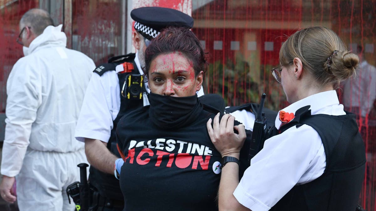 Police detain activists outside APCO Worldwide offices in London.