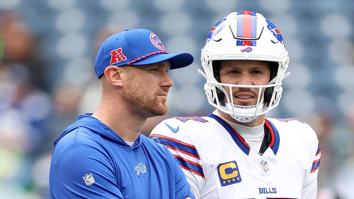 Joe Brady stands next to Josh Allen before a game