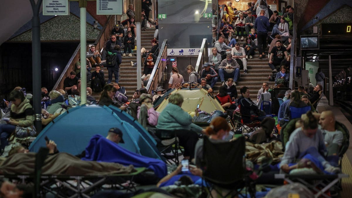 People take shelter inside an overcrowded metro station