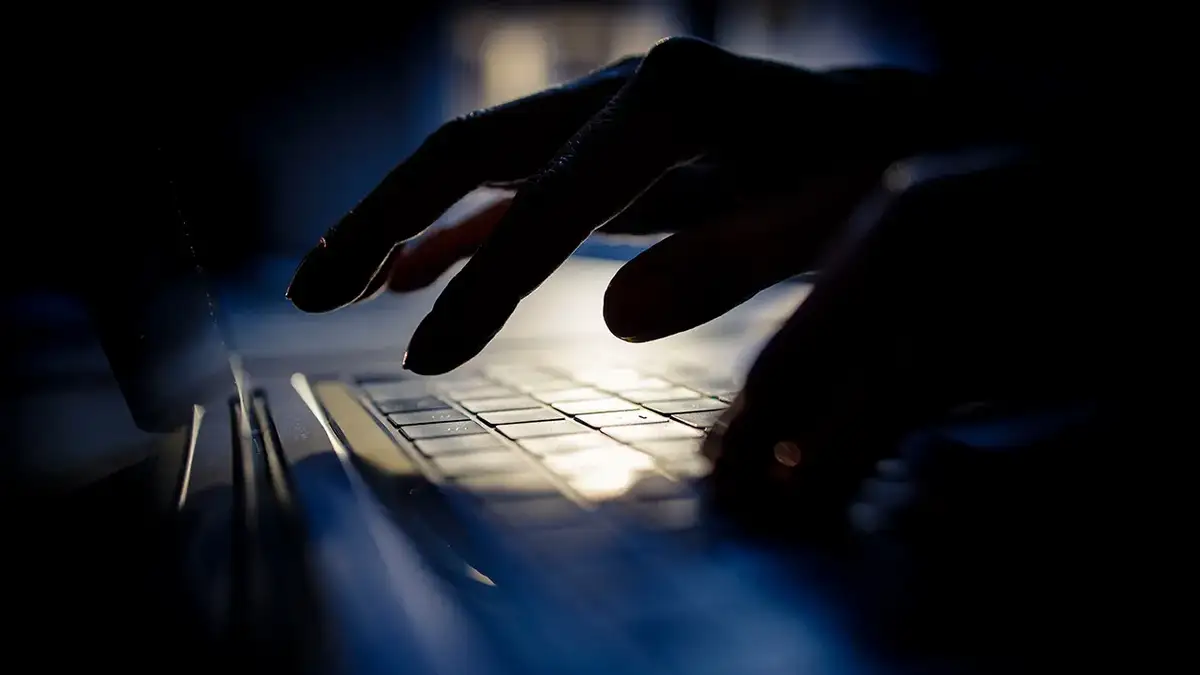 Person typing on their laptop.