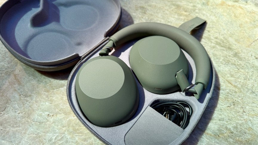 Shot of the Sony WH-1000XM6 in olive gray folded up in their carrying case