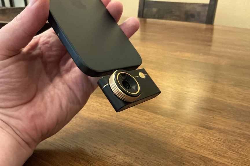 Hand holding the Thermal Master P3 camera on a black phone.