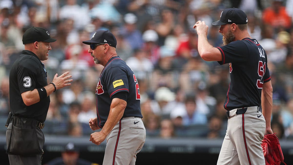 Home plate umpire Dan Merzel talks with manager Walt Weiss and Chris Sale after a balk call at Yankee Stadium.