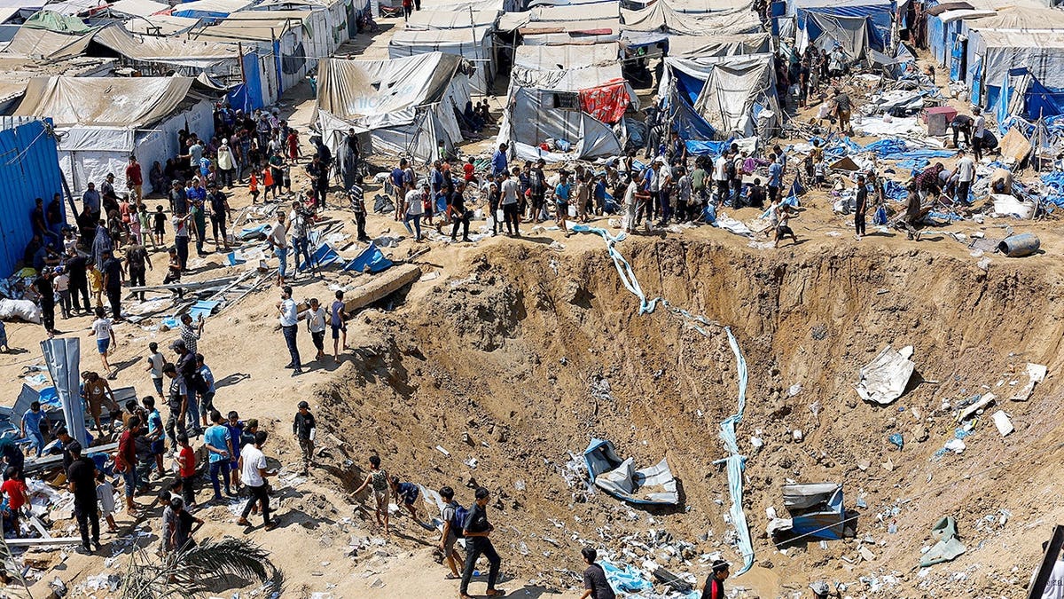 Palestinians inspect the site of an overnight Israeli strike in Gaza