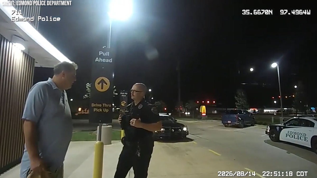 Oklahoma Secretary of State Benjamin Lepak speaks to Edmond police on Aug. 14, 2026, as officers question him outside a McDonald's.