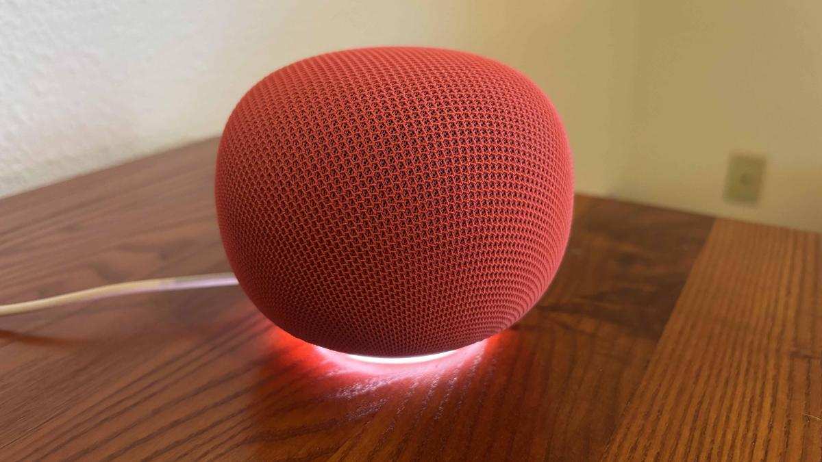 Google's red Home Speaker on a wood table.
