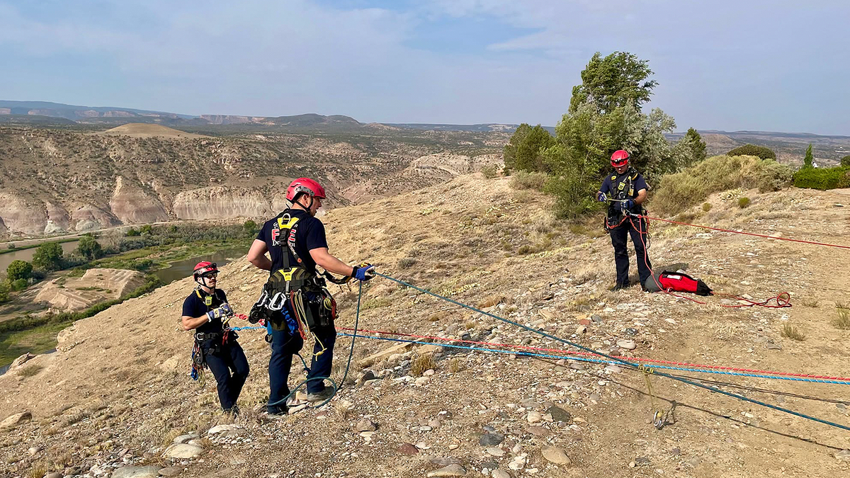 First responders work along the steep hillside near Lookout Lane following a deadly crash