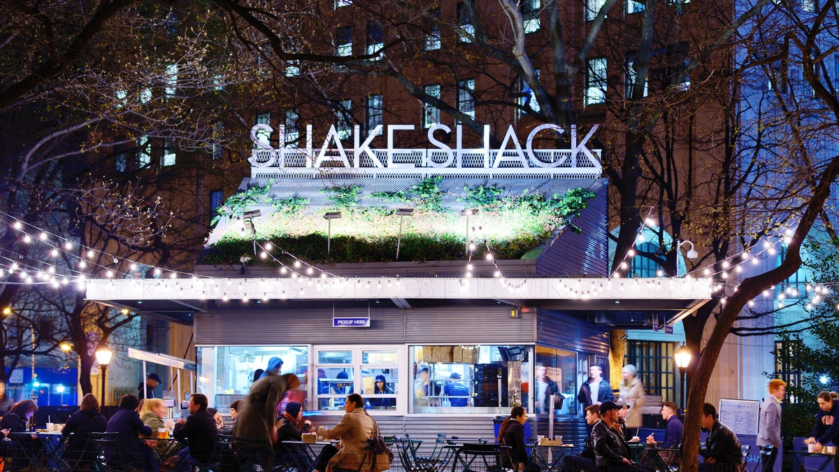 New York City, USA - April 15, 2013: Customers dine at Shake Shack in Madison Square Park. The chain diner opened in 2004 and the Madison Square Park location is the original.