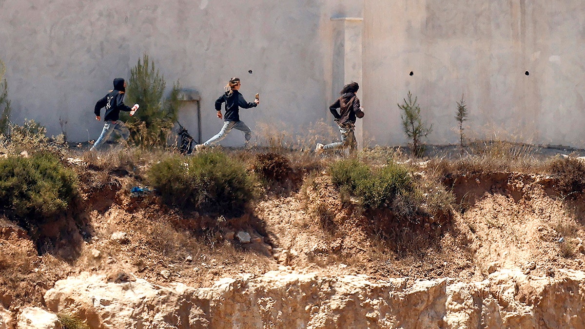 Israeli settlers running from the IDF
