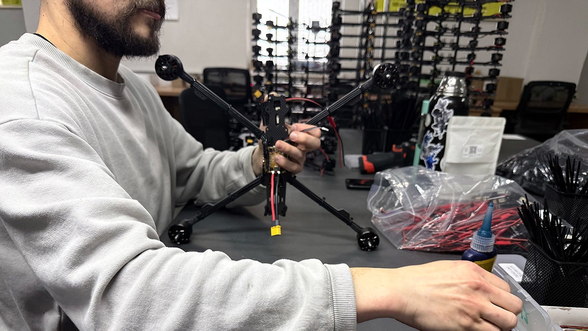 Factory working putting together drones