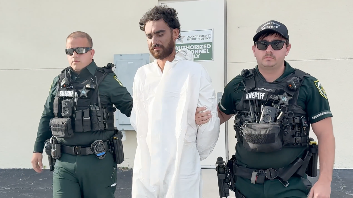 Vazquez is escorted by Orange County Sheriff's deputies