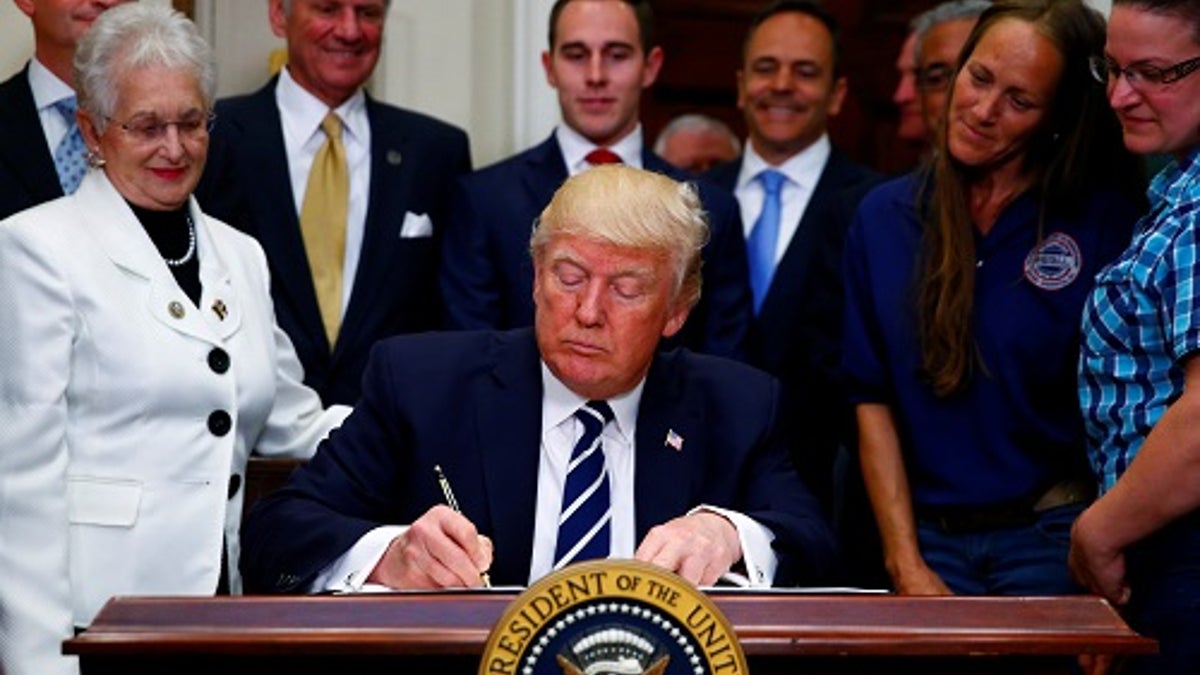 U.S. President Donald Trump signs an executive order at the White House in Washington, U.S. June 15, 2017. REUTERS/Eric Thayer - RTS178B1