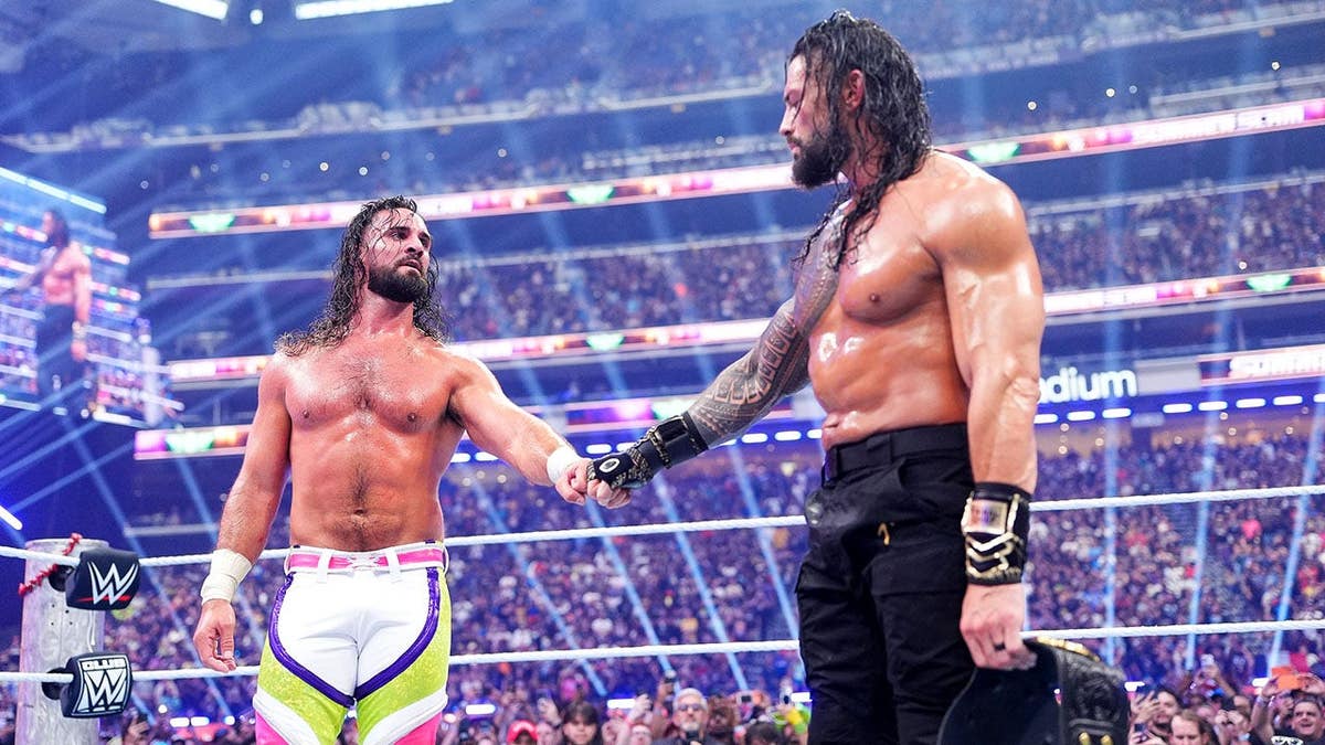 Seth Rollins and Roman Reigns fist bump during SummerSlam at U.S. Bank Stadium.
