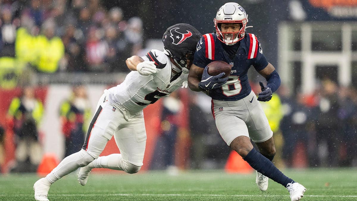Stefon Diggs runs with the ball against Jalen Pitre during an NFL playoff game.