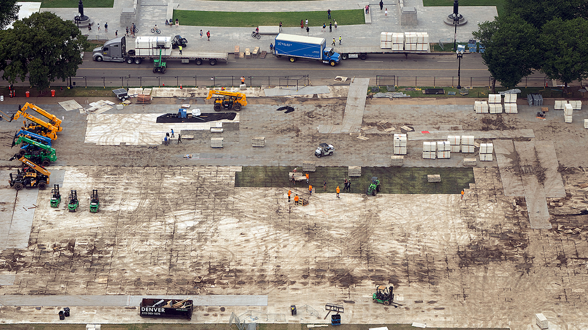 Workers dismantle structures from an Independence Day event