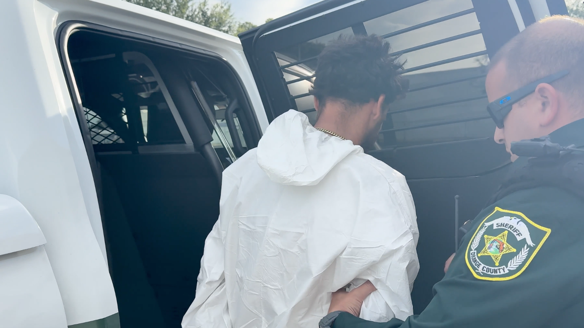 Vazquez is loaded into a police vehicle