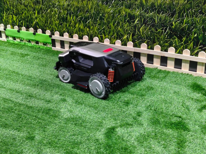 An Anker autonomous mower cutting grass near an edge.