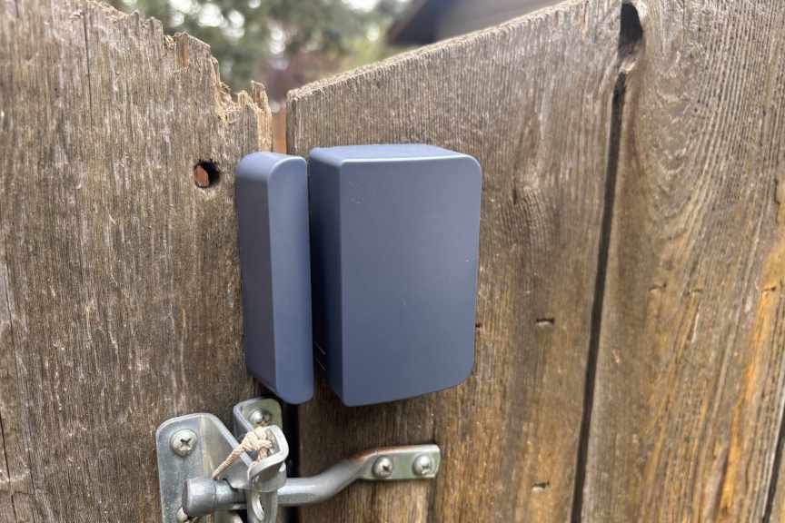An Abode outdoor sensor on a fence.