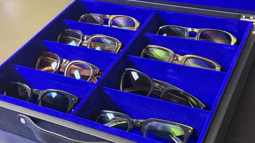 A blue case with a lot of glasses frames inside