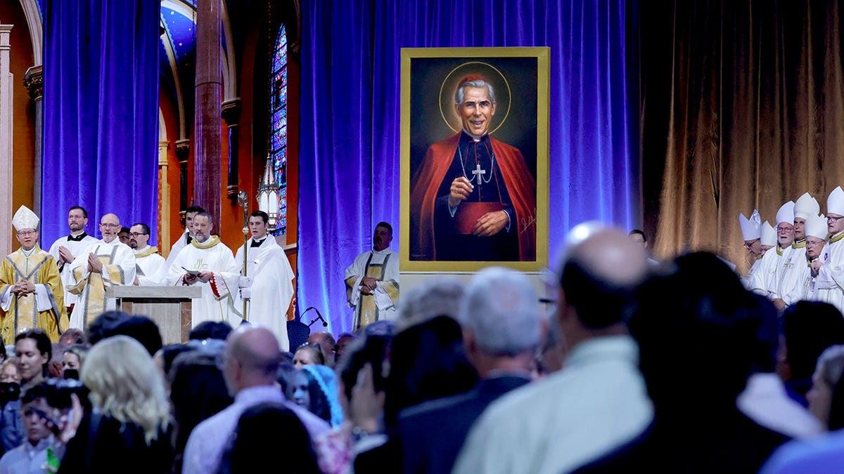 Archbishop Fulton Sheen portrait displayed on stage during beatification ceremony in St. Louis.