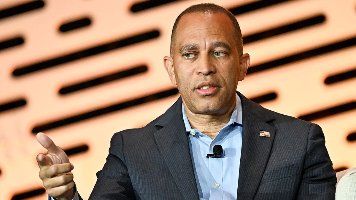 Hakeem Jeffries speaks onstage during a panel discussion at a convention.