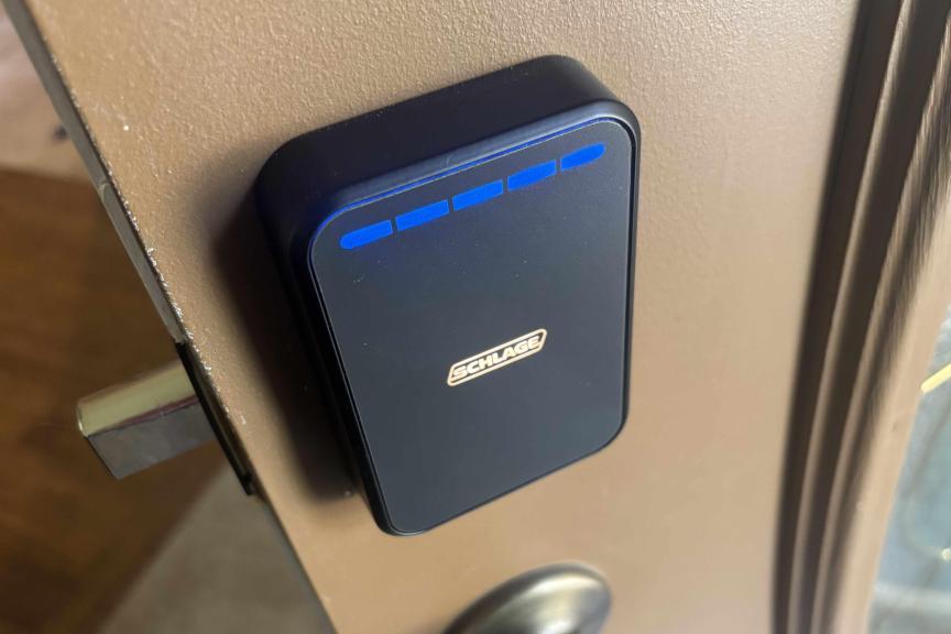 A black Schlage lock pad on a brown, open door.
