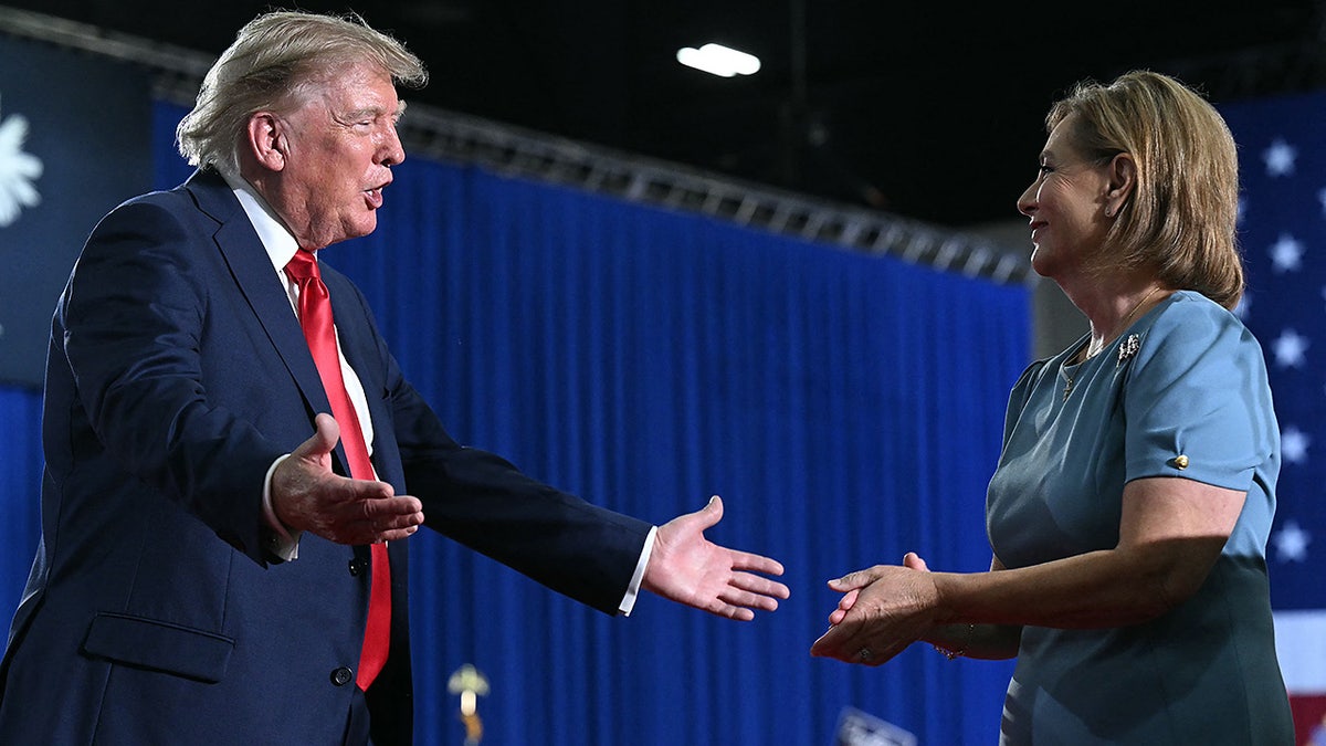 President Donald Trump congratulates US Senator Darline Graham after she spoke during a campaign rally at Myrtle Beach Convention Center in Myrtle Beach, South Carolina on August 21, 2026.